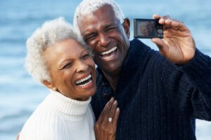 Senior couple with camera on beach sf oral surgery