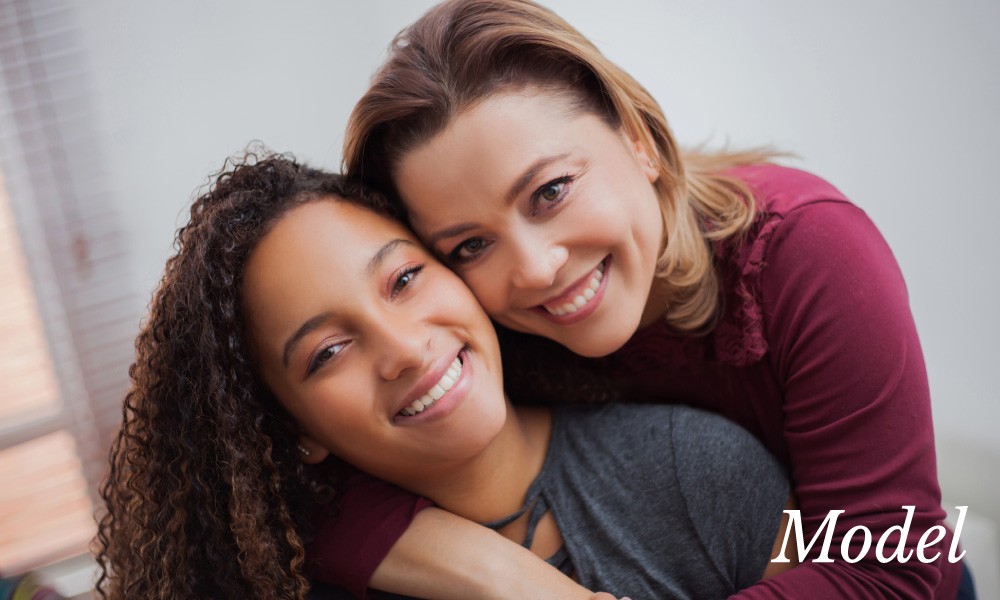 Mom and teenage daughter smiling and hugging sf oral surgery